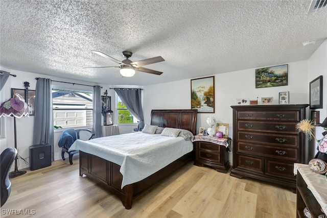 bedroom featuring ceiling fan, a textured ceiling, and light wood-type flooring