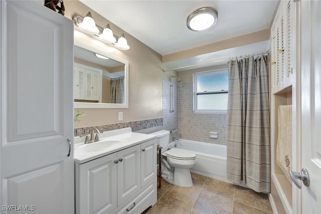 full bathroom featuring shower / tub combo with curtain, vanity, toilet, and tile walls