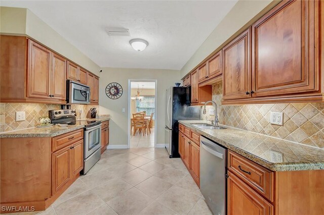 kitchen featuring stainless steel appliances, tasteful backsplash, sink, and light tile patterned floors