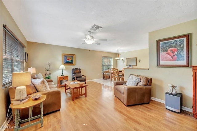 living room featuring ceiling fan, a healthy amount of sunlight, and light wood-type flooring