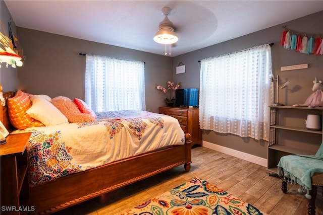 bedroom with light hardwood / wood-style floors and ceiling fan