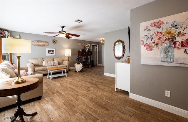 living room with wood-type flooring and ceiling fan