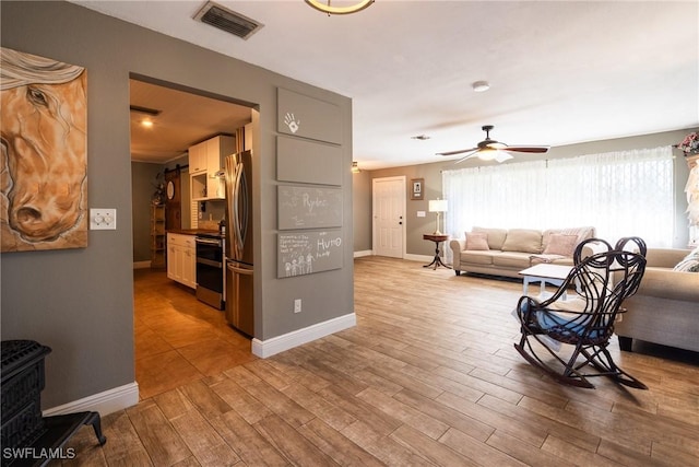 living room with light hardwood / wood-style floors and ceiling fan