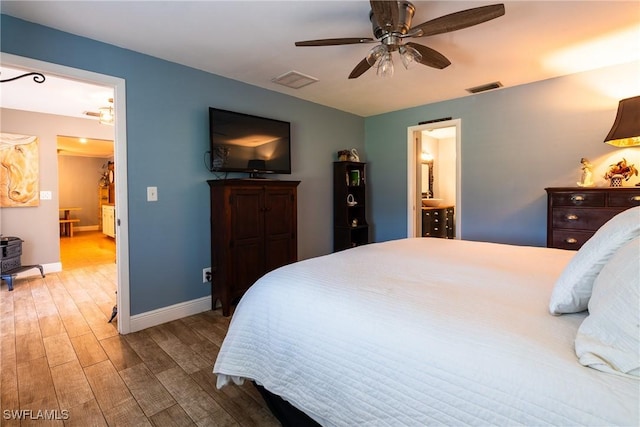 bedroom with hardwood / wood-style flooring, ceiling fan, and ensuite bath