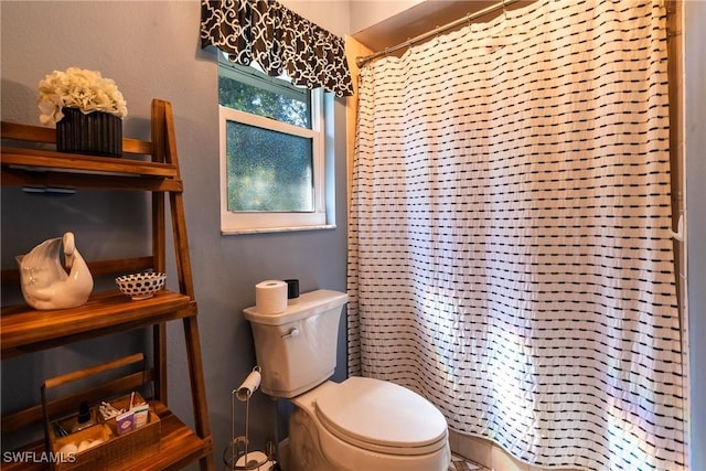 bathroom featuring walk in shower and toilet