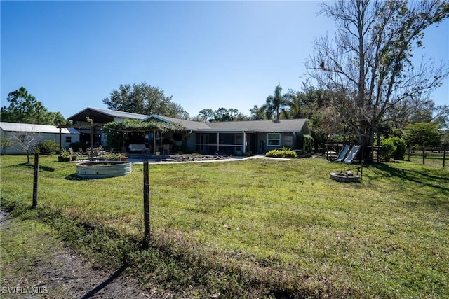 rear view of property featuring a sunroom and a lawn