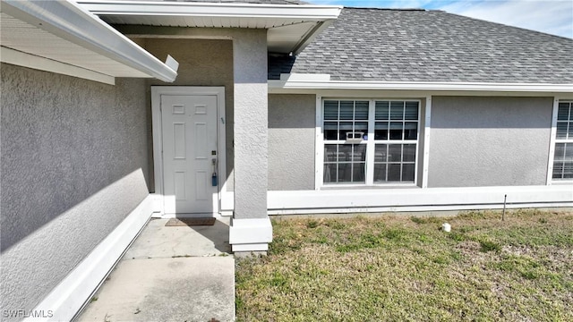 doorway to property featuring a lawn