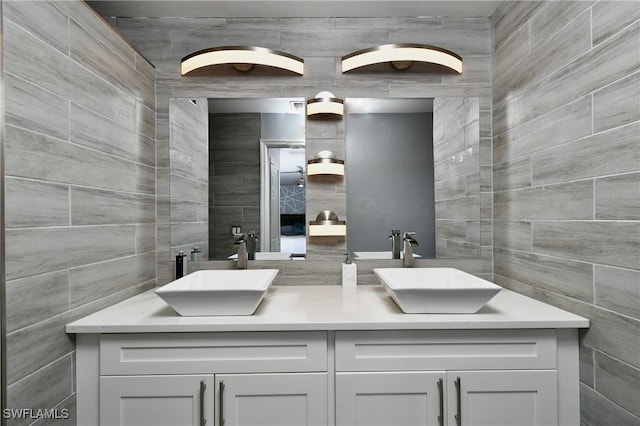 bathroom featuring vanity and tile walls