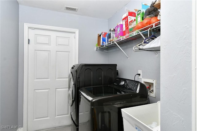 washroom with sink and independent washer and dryer