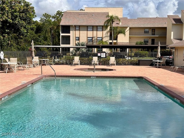 pool with a patio area and fence