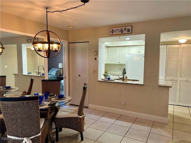 dining area featuring light tile patterned flooring and a notable chandelier