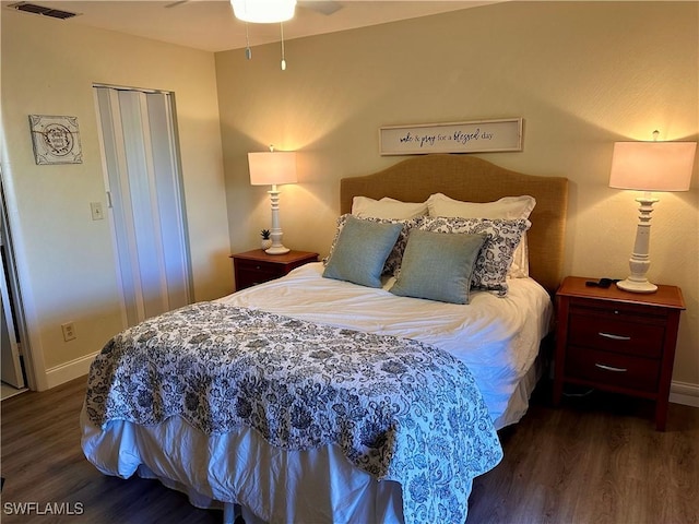 bedroom featuring baseboards, visible vents, and wood finished floors