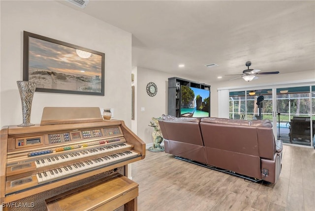 living room featuring ceiling fan and light hardwood / wood-style floors