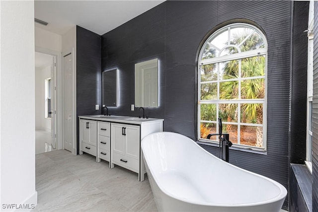 bathroom featuring vanity and a bath