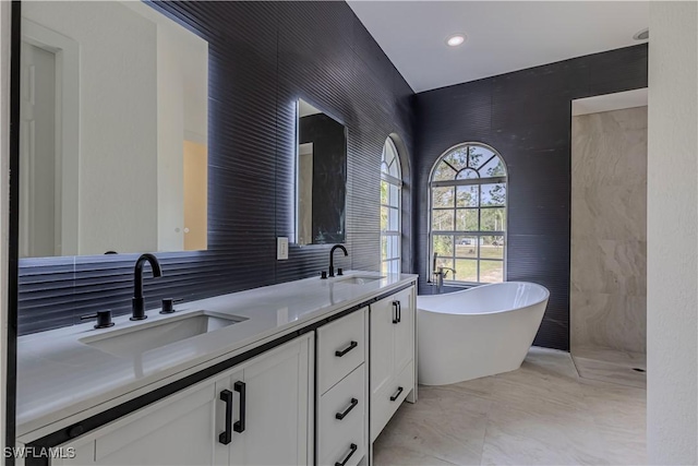 bathroom with vanity, tile walls, and a washtub