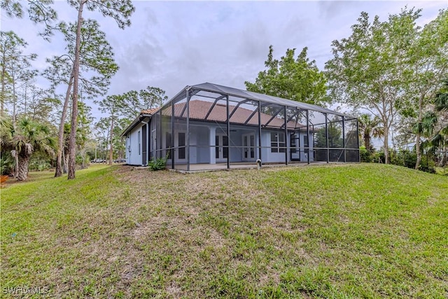 back of house featuring a lanai, a yard, and a patio area