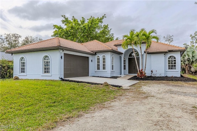 mediterranean / spanish house with a garage and a front yard