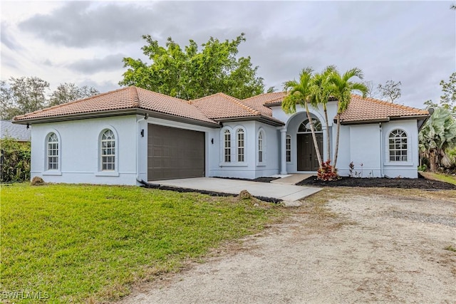 4273 18th St NE, Naples, FL 34120 - mediterranean / spanish house featuring a tile roof, an attached garage, stucco siding, and a front lawn