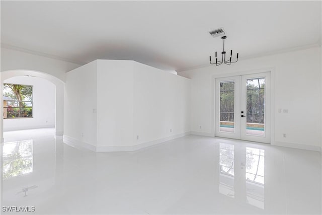 empty room with french doors and a chandelier