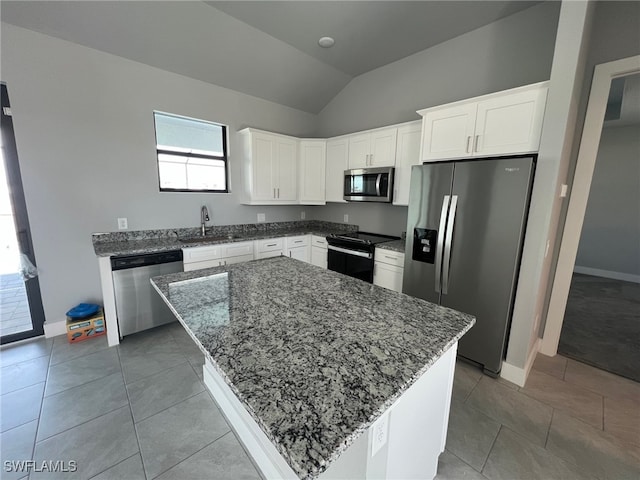 kitchen featuring sink, light tile patterned floors, white cabinetry, stainless steel appliances, and a kitchen island