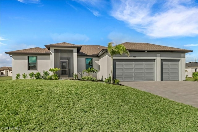 prairie-style house with driveway, an attached garage, a front yard, and stucco siding