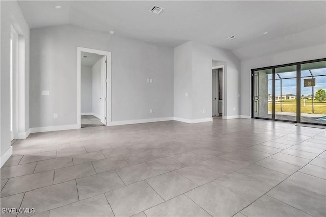 empty room featuring lofted ceiling, baseboards, visible vents, and light tile patterned flooring