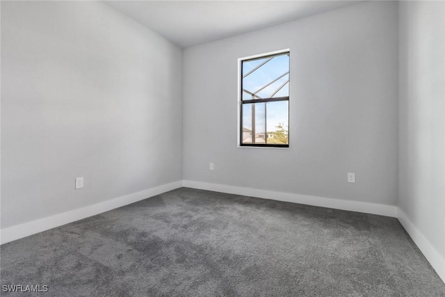 carpeted spare room with baseboards