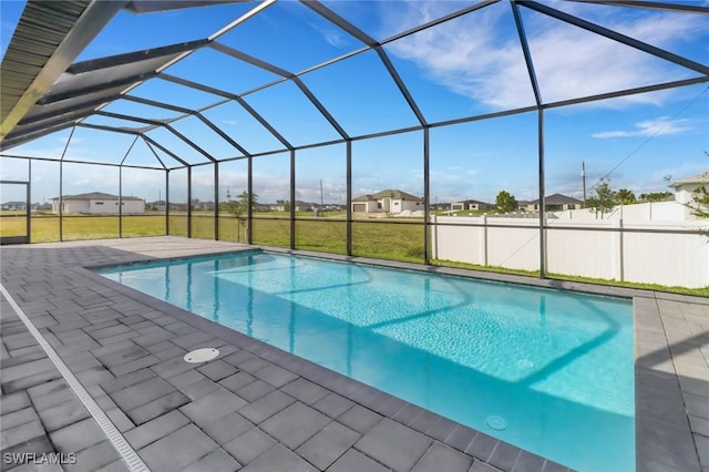 pool with a patio, a residential view, fence, and glass enclosure