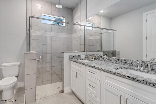 bathroom featuring tile patterned flooring, a sink, toilet, and a shower stall