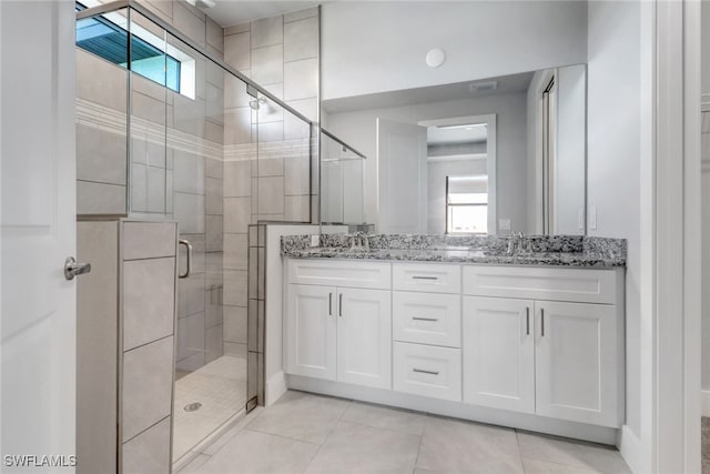 bathroom with a wealth of natural light, a sink, a shower stall, and double vanity