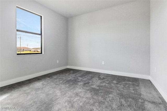 carpeted spare room with baseboards