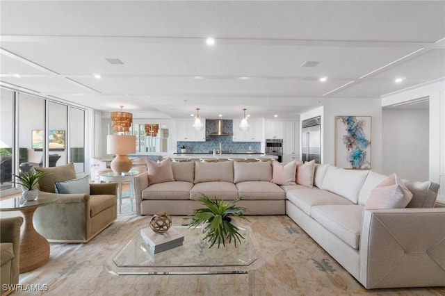 living room featuring a healthy amount of sunlight, sink, and light hardwood / wood-style flooring