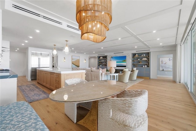 dining space featuring sink, built in features, and light hardwood / wood-style floors