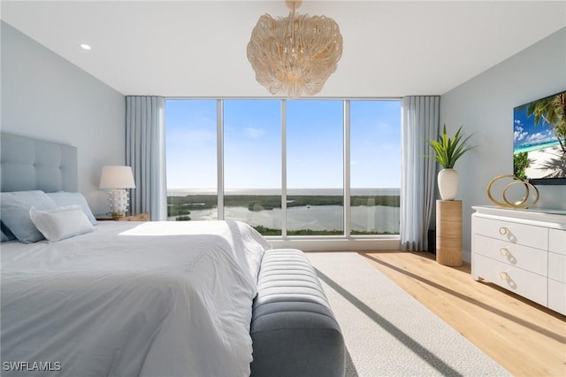 bedroom featuring hardwood / wood-style floors, floor to ceiling windows, and a chandelier