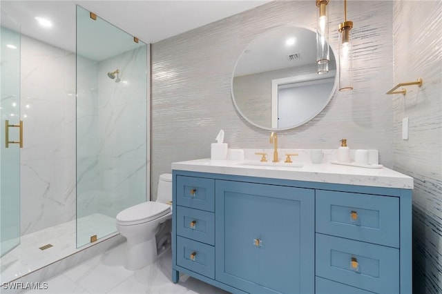 bathroom with tile walls, vanity, a shower with door, and toilet