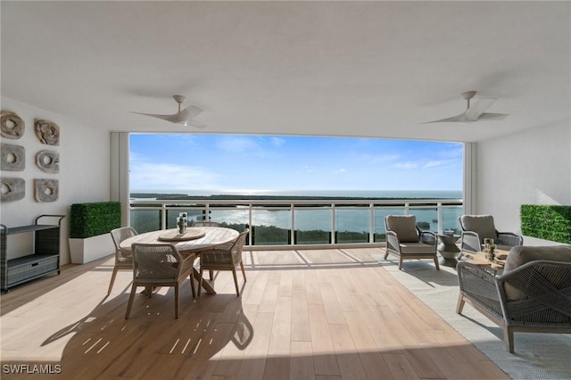 view of patio with an outdoor living space, a water view, and ceiling fan