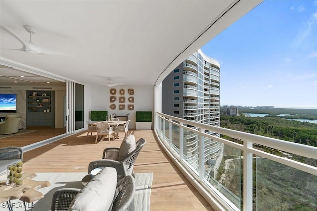 balcony featuring ceiling fan and a water view