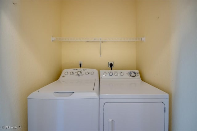 clothes washing area with washer and clothes dryer