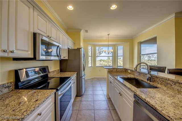 kitchen featuring decorative light fixtures, white cabinetry, sink, ornamental molding, and stainless steel appliances