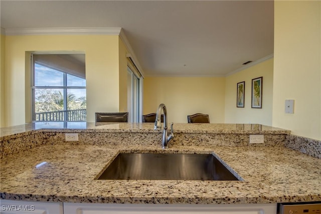 kitchen with crown molding, sink, and light stone counters