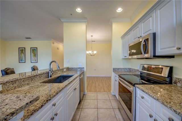 kitchen with sink, crown molding, pendant lighting, stainless steel appliances, and white cabinets