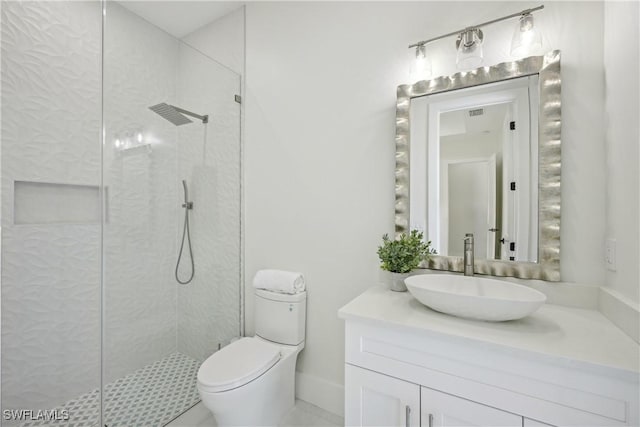 bathroom with vanity, a tile shower, and toilet