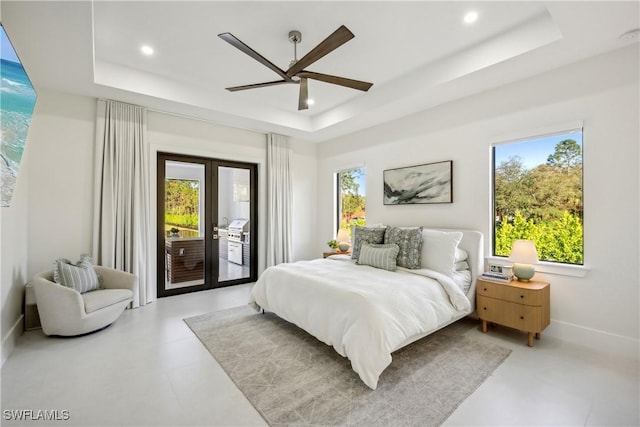 bedroom featuring a raised ceiling, access to exterior, multiple windows, and french doors