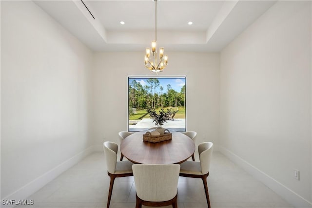 dining area featuring an inviting chandelier and a raised ceiling