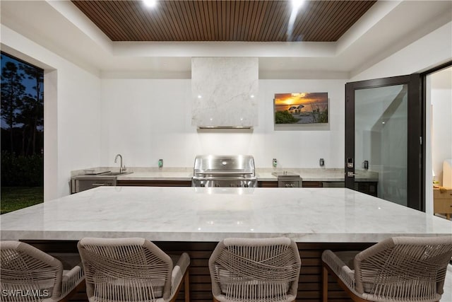 kitchen featuring range, a tray ceiling, and wooden ceiling