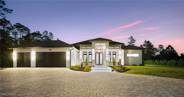 prairie-style home with a garage and a lawn