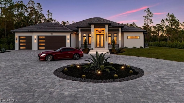 prairie-style house with a garage and a yard