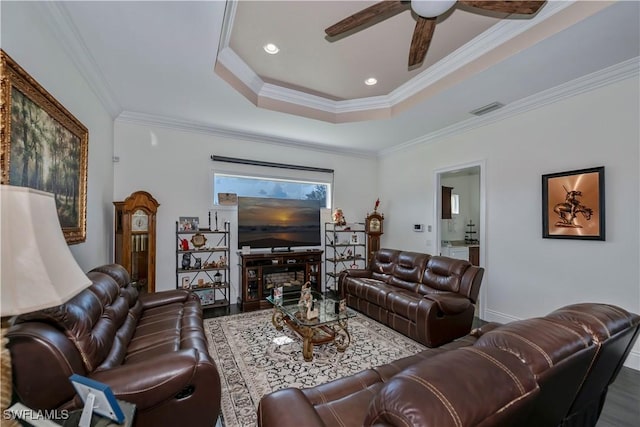 living room featuring crown molding, ceiling fan, a raised ceiling, and hardwood / wood-style flooring