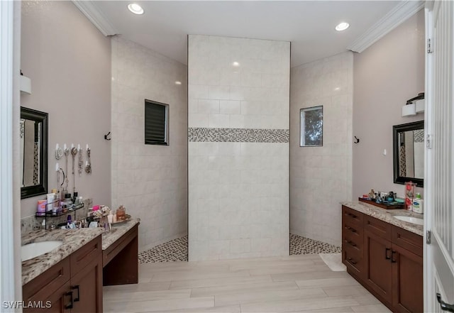 bathroom with crown molding, vanity, and a tile shower