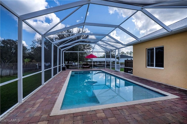 view of swimming pool featuring a patio and a lanai